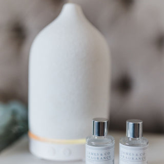 Electric Luxury Diffuser sat in counter next to two diffuser oils