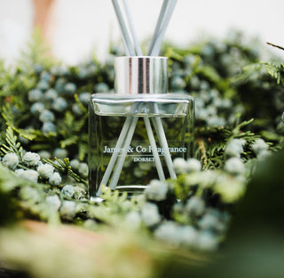 The base of a clear reed differ jar nestled between green foliage.