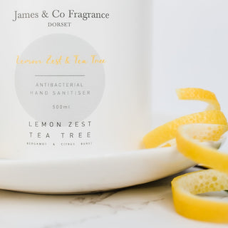 Bottle of 500ml tea tree and lemon antibacterial hand sanitiser placed next to lemon peel and tea tree leaves