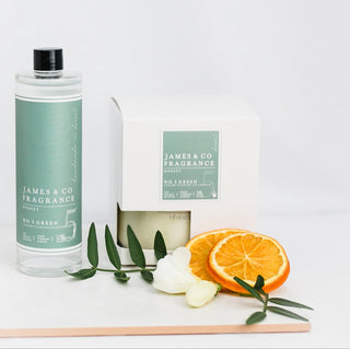 Our No. 5 Green 200ml reed diffuser refill sits next to cotton flowers and orange slices