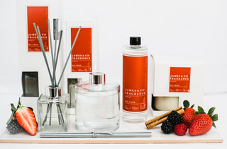 Our No. 4 Red 200ml diffuser refill, next to wild strawberries, raspberries, blackberries, and a cinnamon stick