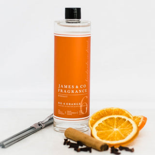 Our No. 6 Orange 200ml diffuser refill sat with sweet tangerine slices, cinnamon sticks, and a handful of cloves