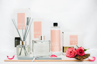 Various pieces from the rose collection, with refill oils, candles and a reed diffuser visible.