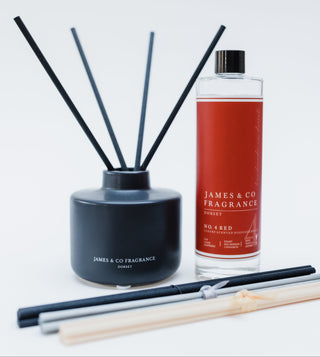 Black diffuser with reeds and a red bottle labeled 'James & Co Fragrance' on a white background