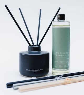 Reed diffuser set with black container and bottle labeled 'James & Co Fragrance' on a light gray background