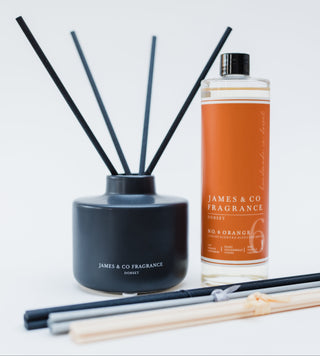 Reed diffuser set with black container and orange bottle labeled 'James & Co Fragrance' on a white background.