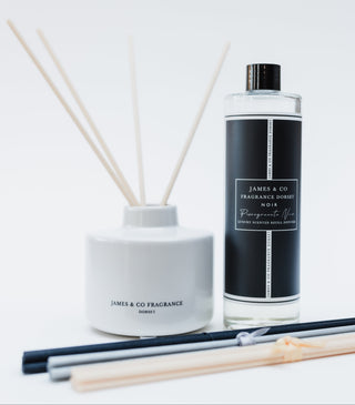 Reed diffuser set with bottle, container, and sticks on a white background