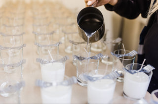 Person pouring liquid into small glass cups with a blurred background
