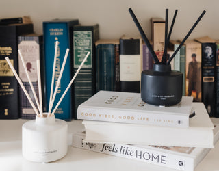 Two diffusers on books with a blurred bookshelf background