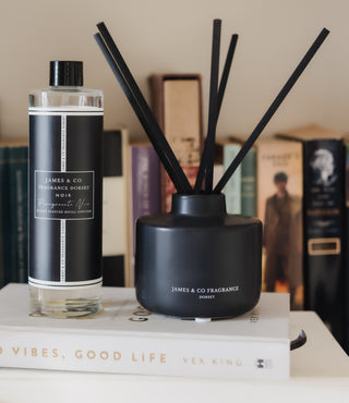 Black diffuser and bottle on a book with blurred background