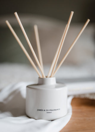 White diffuser with wooden sticks on a soft fabric background