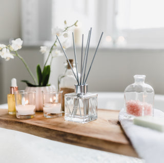 Aromatherapy diffuser with candles and flowers on a wooden surface