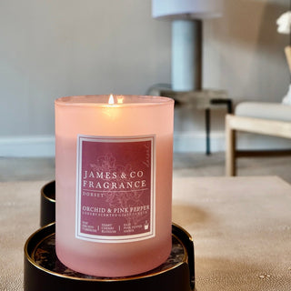 Hand-poured Orchid & Pink Pepper candle by James & Co Fragrance, emitting a warm autumn glow in a soft blush jar.