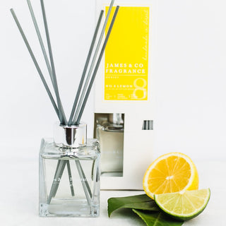 Our No. 8 Lemon 100ml reed diffuser sat with lemon wedges and bergamot leaves