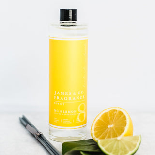 Our No. 8 Lemon 200ml diffuser refill sat with lemon wedges and bergamot leaves