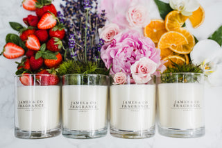 Four James & Co. Fragrance candles with flowers and fruits in the background.
