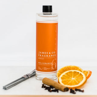 Our No. 6 Orange 200ml diffuser refill sat with sweet tangerine slices, cinnamon sticks, and a handful of cloves