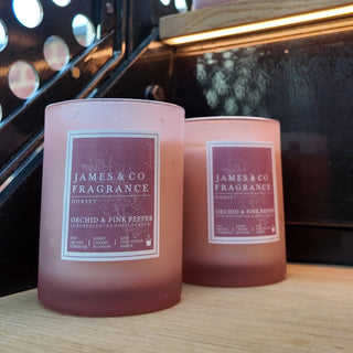 Two pink frosted glass car candles on a stair case. 