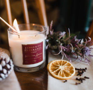 A close-up of the Winter Spice Luxury 2-wick candle against a festive background.